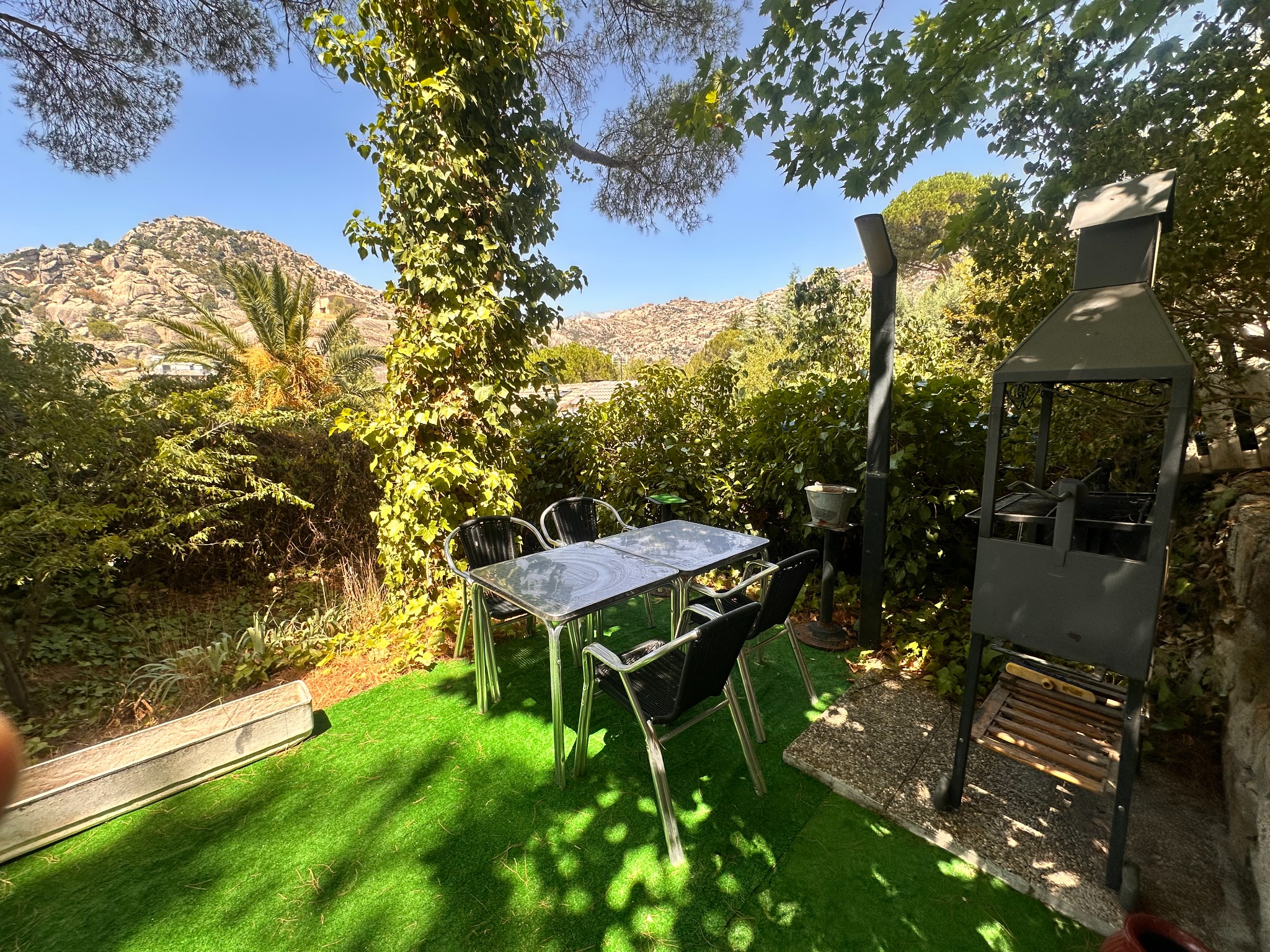 Zona exterior con mesa, barbacoa y vistas a La Pedriza
